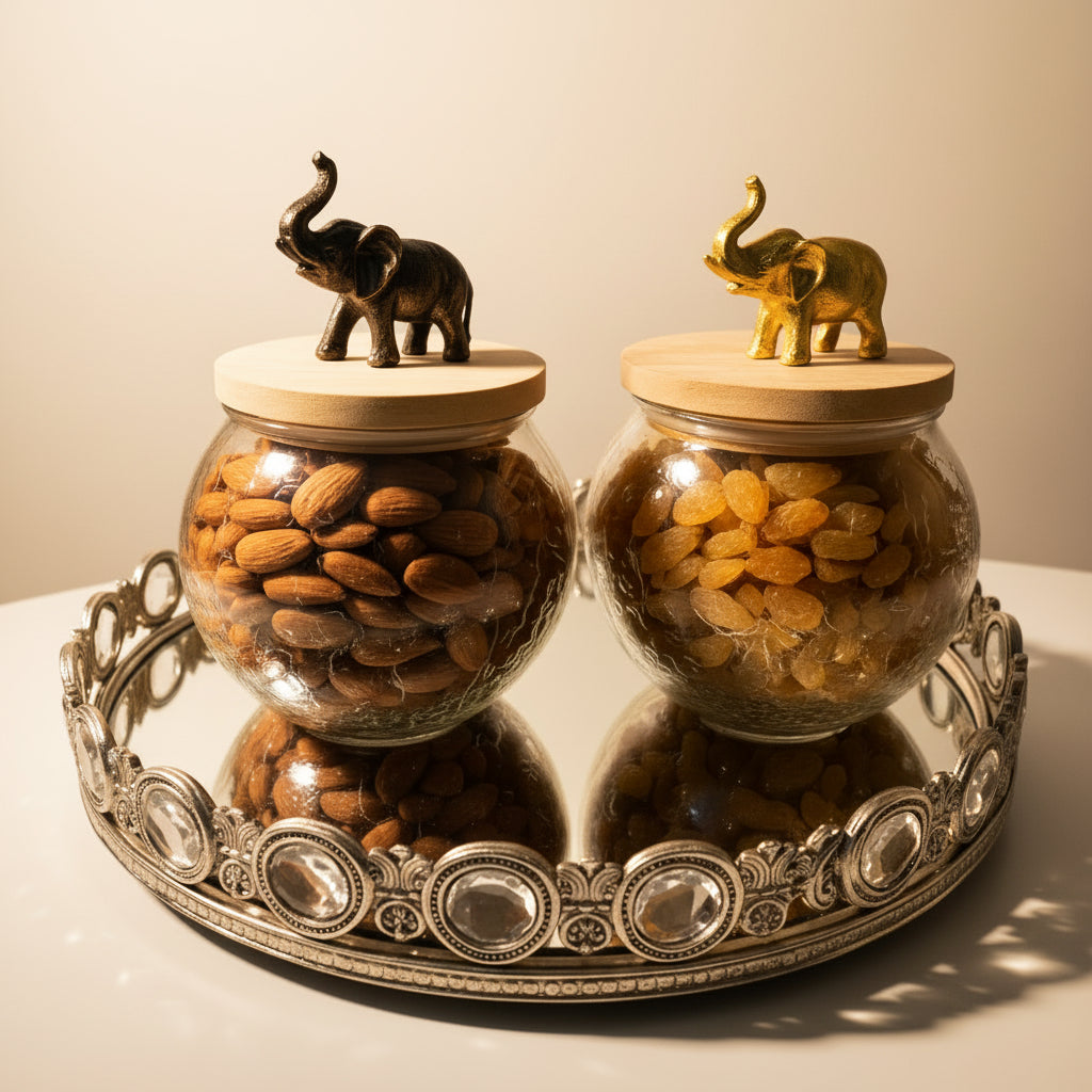Two glass jars with wooden lids containing almonds and raisins, each topped with an elephant figurine, on a decorative tray.